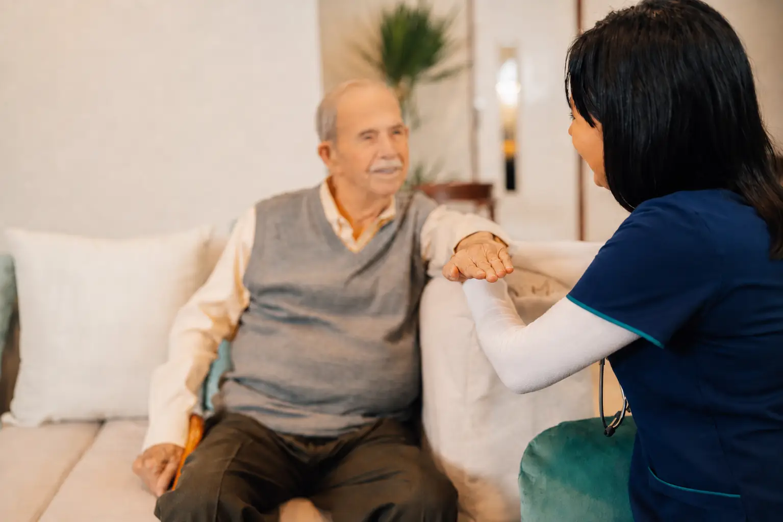 nurse and old man sitting holding hands